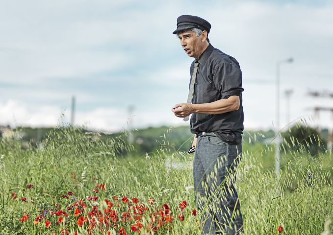 photographie de Jean-Marc Zanaroli discourant debout dans les herbes et les coquelicots