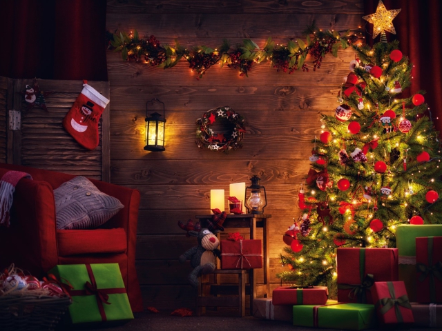 Photographie d'un intérieur boisé et décoré aux couleurs de Noël, sapin inclus