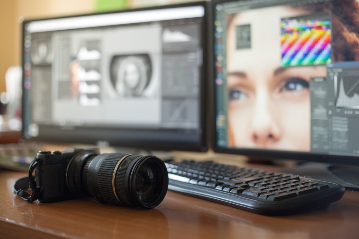 photographie d'un appareil photo posé sur un bureau, avec un ordinateur en arrière plan