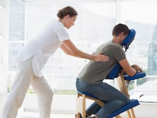 photographie d'une personne installée sur une chaise de massage assis