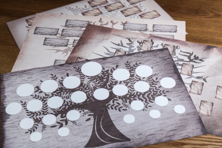 photographie de plusieurs feuilles de papier posées sur une table avec un motif d'arbre généalogique à remplir