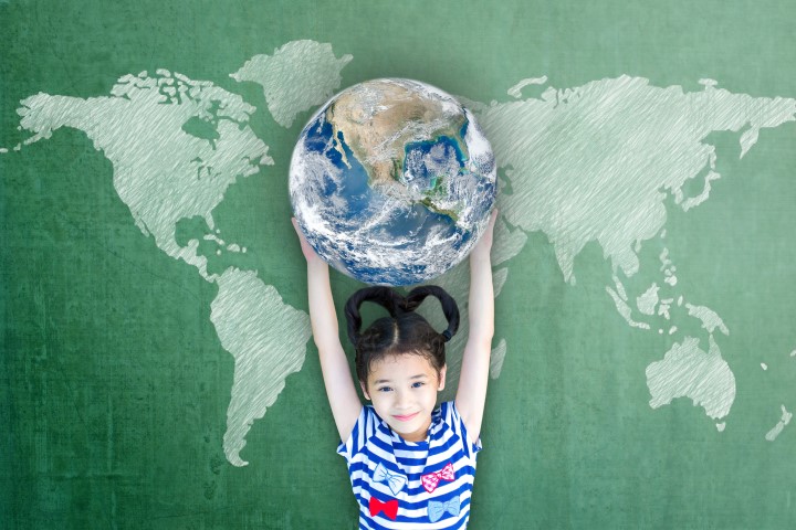 photographie d'une fille tenant un globe terrestre en les mains au-dessus de sa tête