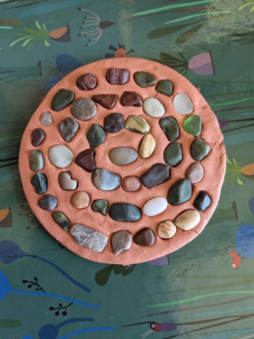 Une spirale de cailloux dans une galette d'argile
