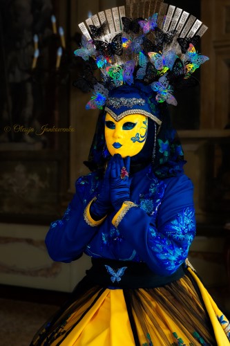 Une personne costumée à la mode vénitienne bleu et or