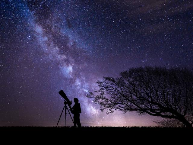 silhouette d'astronome devant ciel étoilé