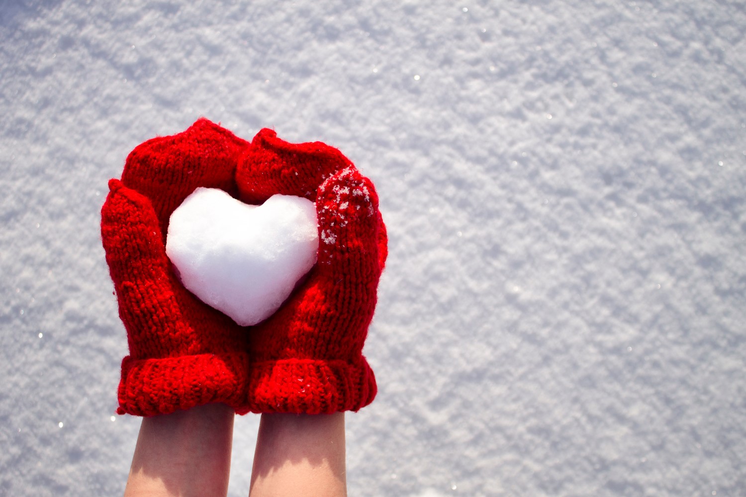 boule de neige en coeur dans moufles rouges